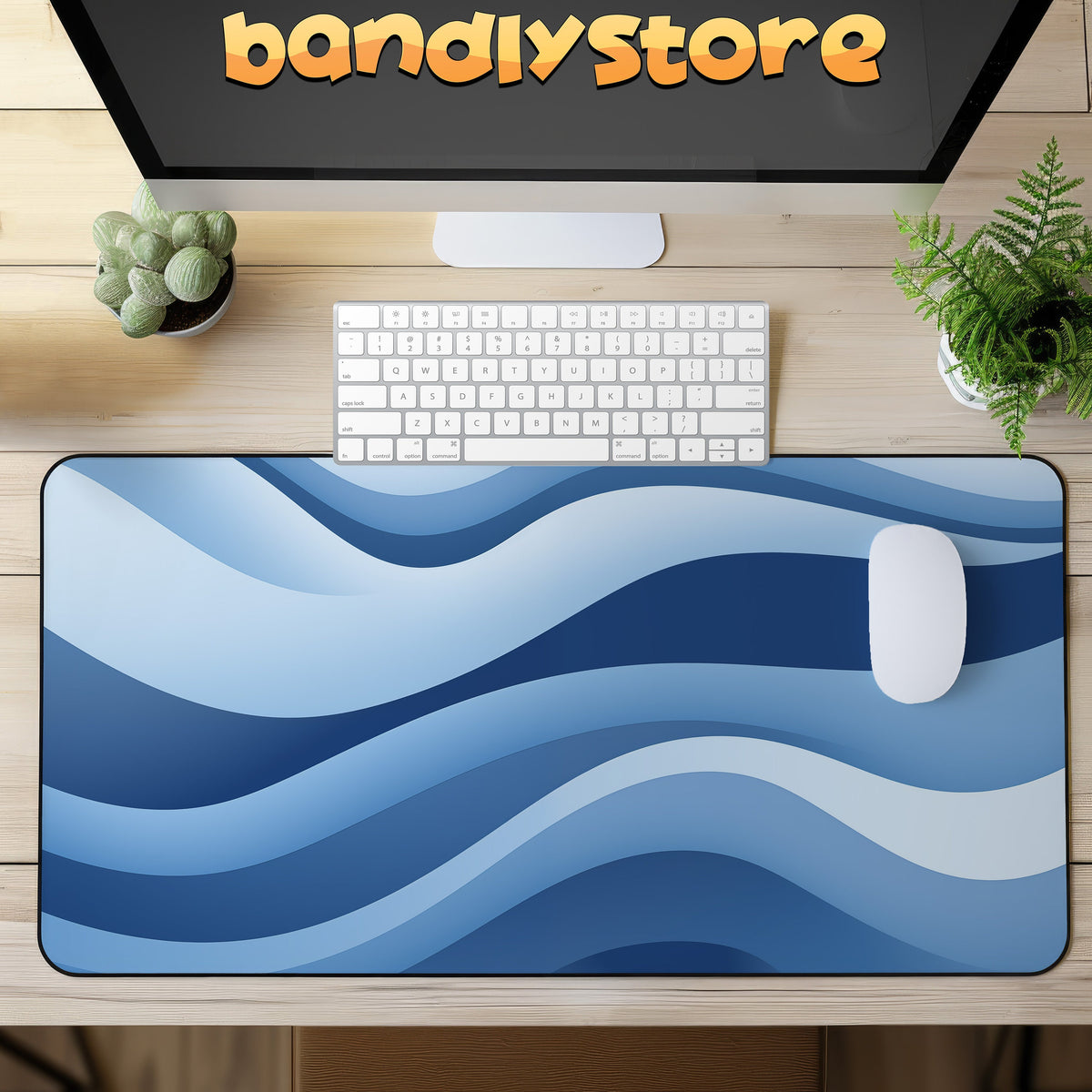 Abstract Desk Mat on a light wood desk with keyboard, mouse, monitor showing bandivstore, and plants.