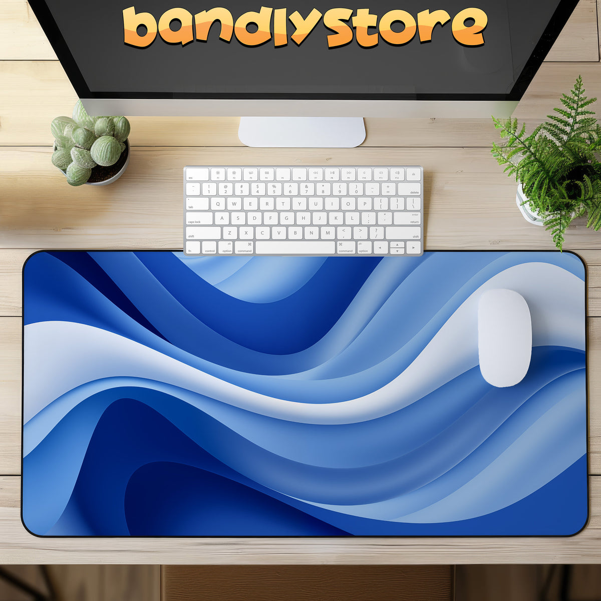 Abstract Blue Ocean Desk Mat on a wooden desk in top-down view with a monitor, keyboard, mouse and plants.