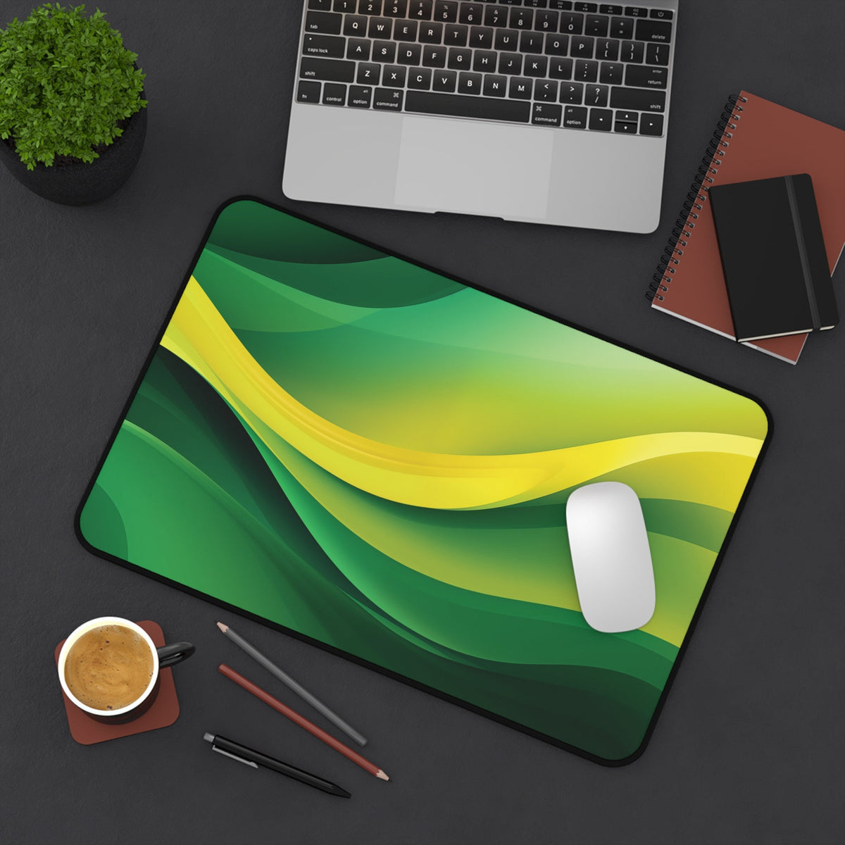 Abstract Desk Mat 12 × 18 inches on a dark desk with laptop, plant, notebooks, coffee, pens and mouse, overhead view.