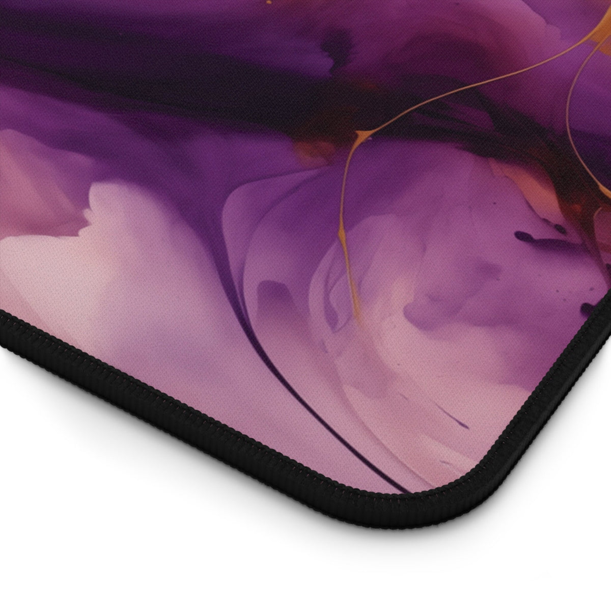 Abstract Purple And Gold Desk Mat close-up of the black-stitched corner on a plain white background.