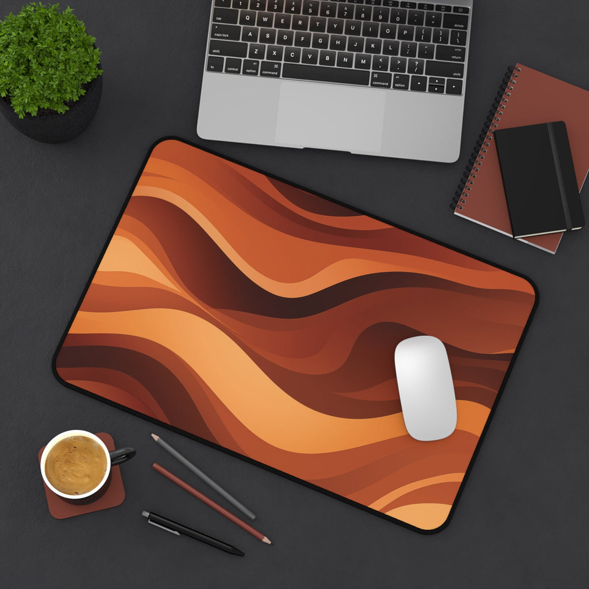 Abstract Wavy Desk Mat in overhead view on a desk with laptop, plant, notebooks, mouse, coffee and pens, 12 ร 18 inches.