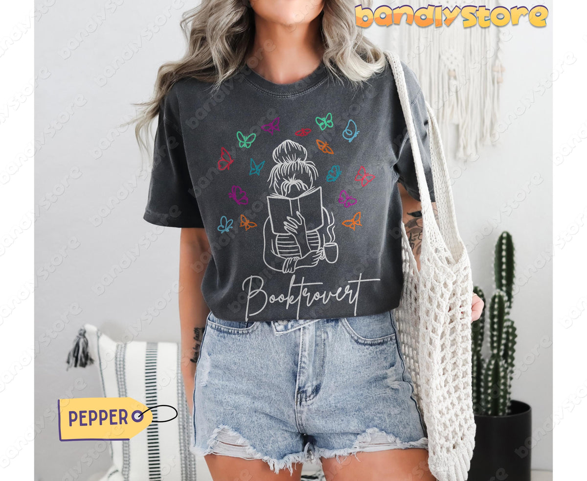 Booktrovert T-Shirt in Pepper, modelled front-on with a tote bag, cactus and wall hangings nearby.