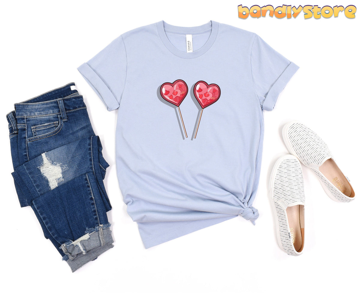 Cute Candy Hearts T-Shirt in light blue flat-laid from above beside ripped jeans and striped slip-ons.