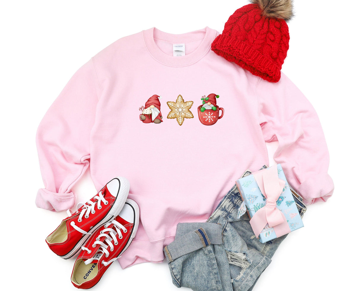 Christmas Gnomes Gingerbread Sweatshirt in light pink laid flat with red beanie, sneakers, jeans and gift.