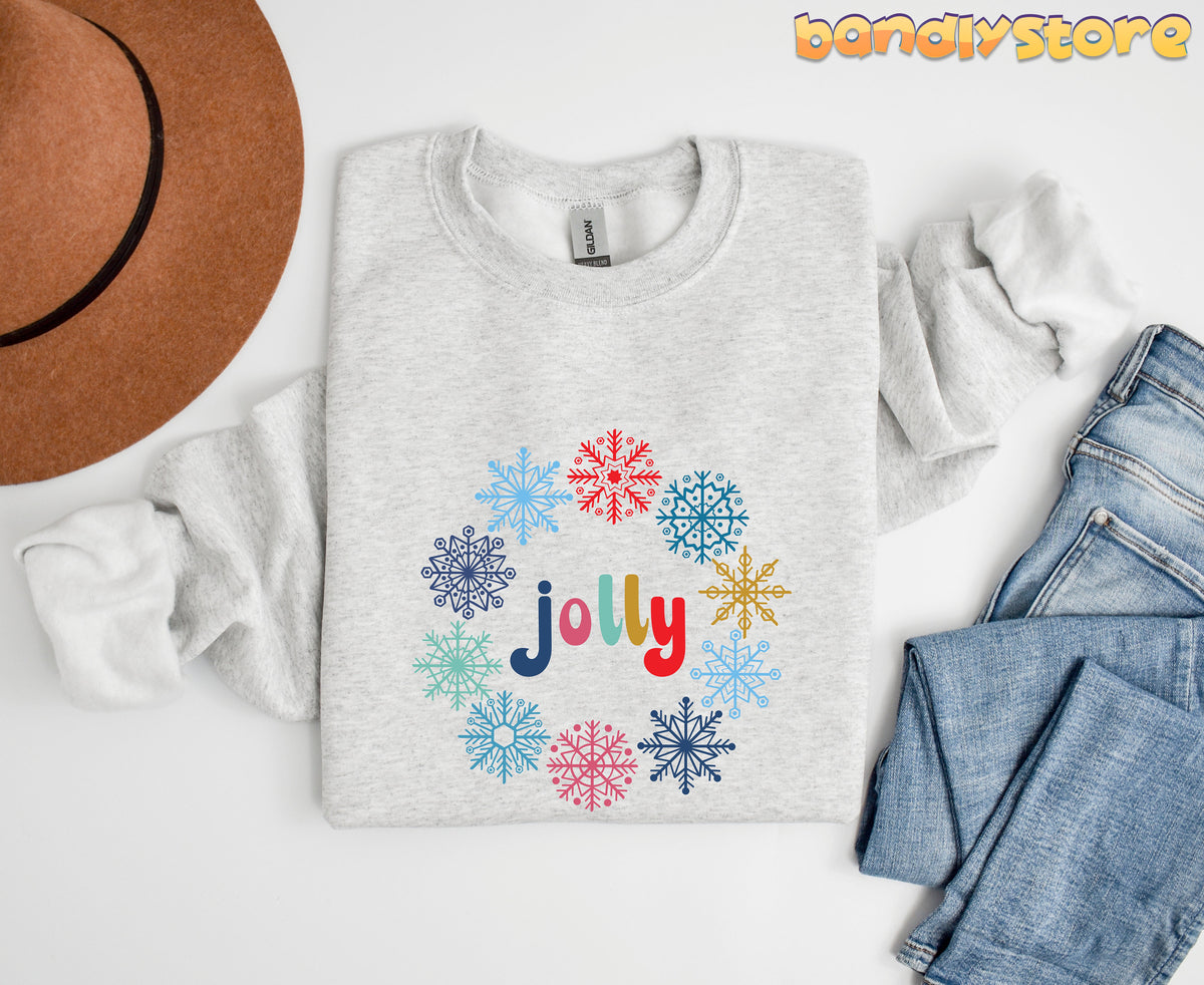 Jolly Snowflake Sweatshirt in ash laid flat on white surface beside brown hat and blue jeans.