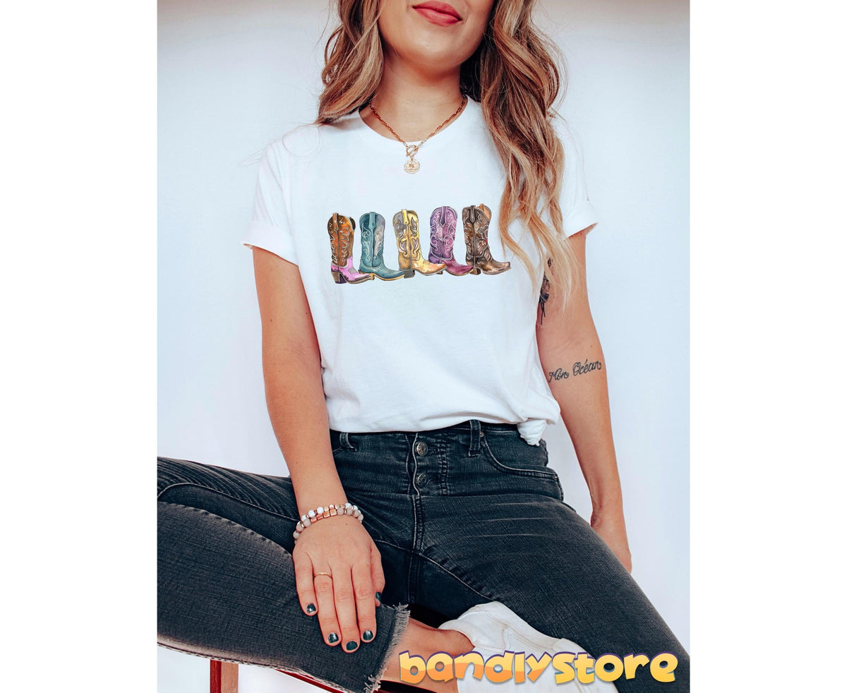 Cowgirl Boots T-Shirt in white on a seated woman facing forward against a plain wall.
