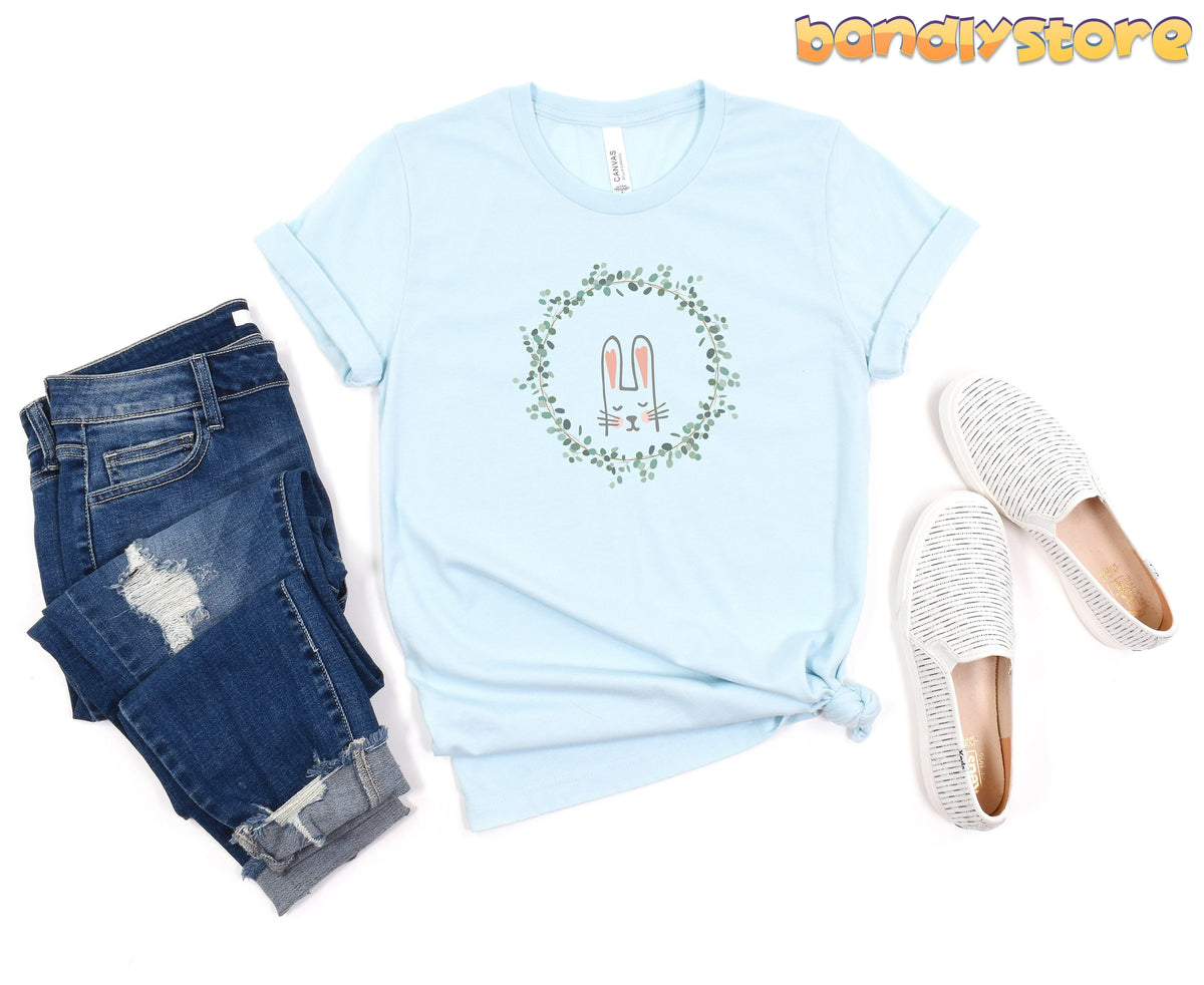 Cute Bunny T-Shirt in Heather Ice Blue laid flat between ripped blue jeans and white slip-on shoes.