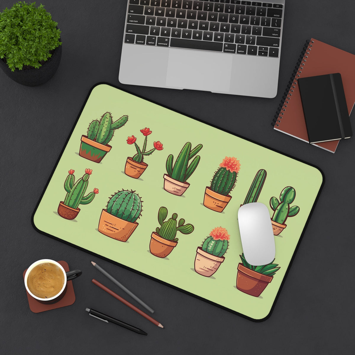 Cute Cactus Desk Mat 12 × 18 inches on a dark desk from above with laptop, mouse, plant, coffee and notebooks.