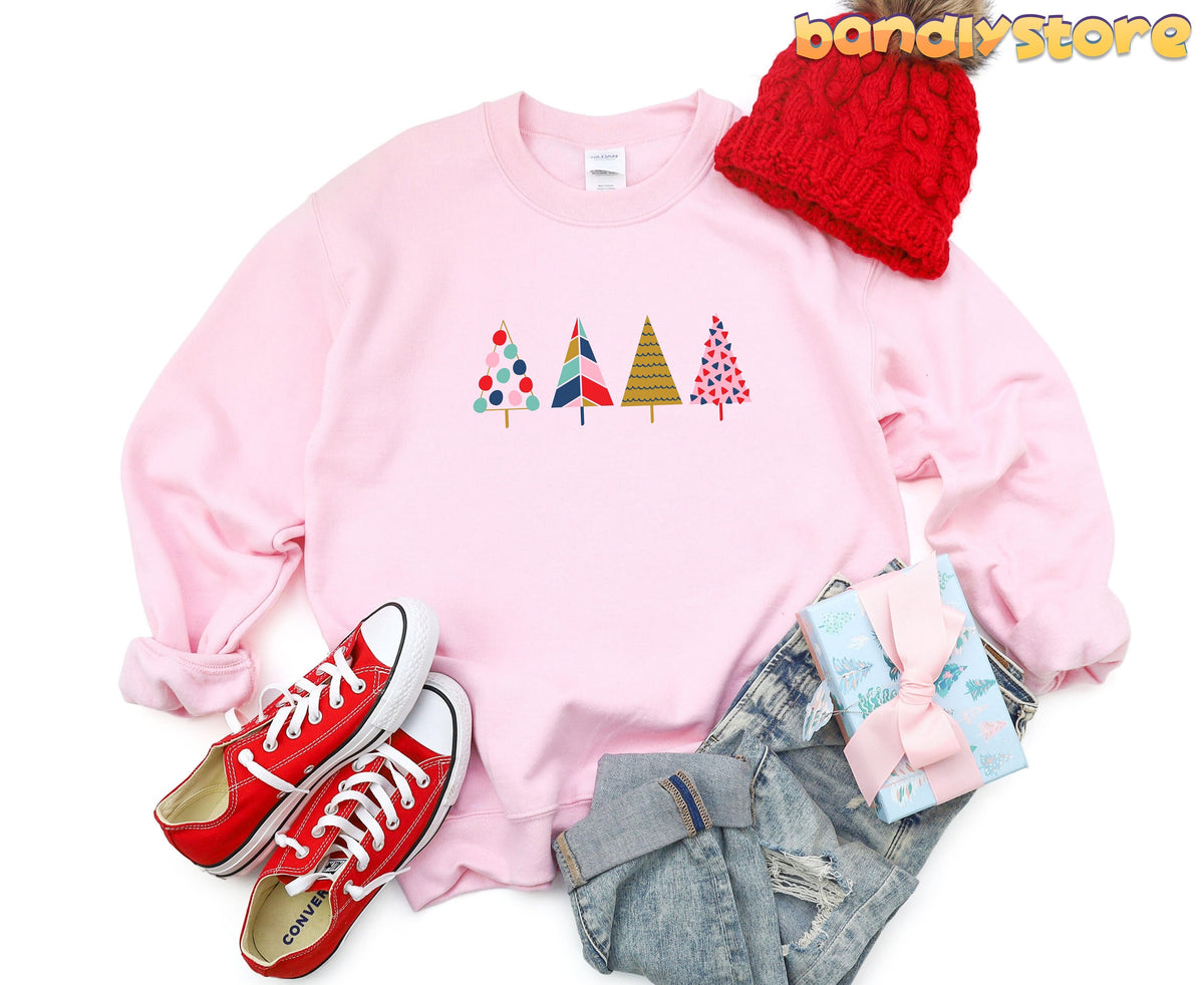 Cute Christmas Trees Sweatshirt in light pink laid flat with red beanie, red sneakers, jeans and gift.