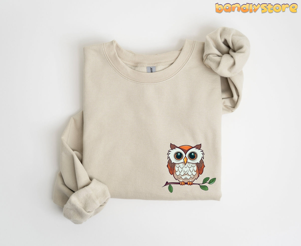 Cute Owl Sweatshirt with Pocket Design in sand, folded flat on a plain white background.