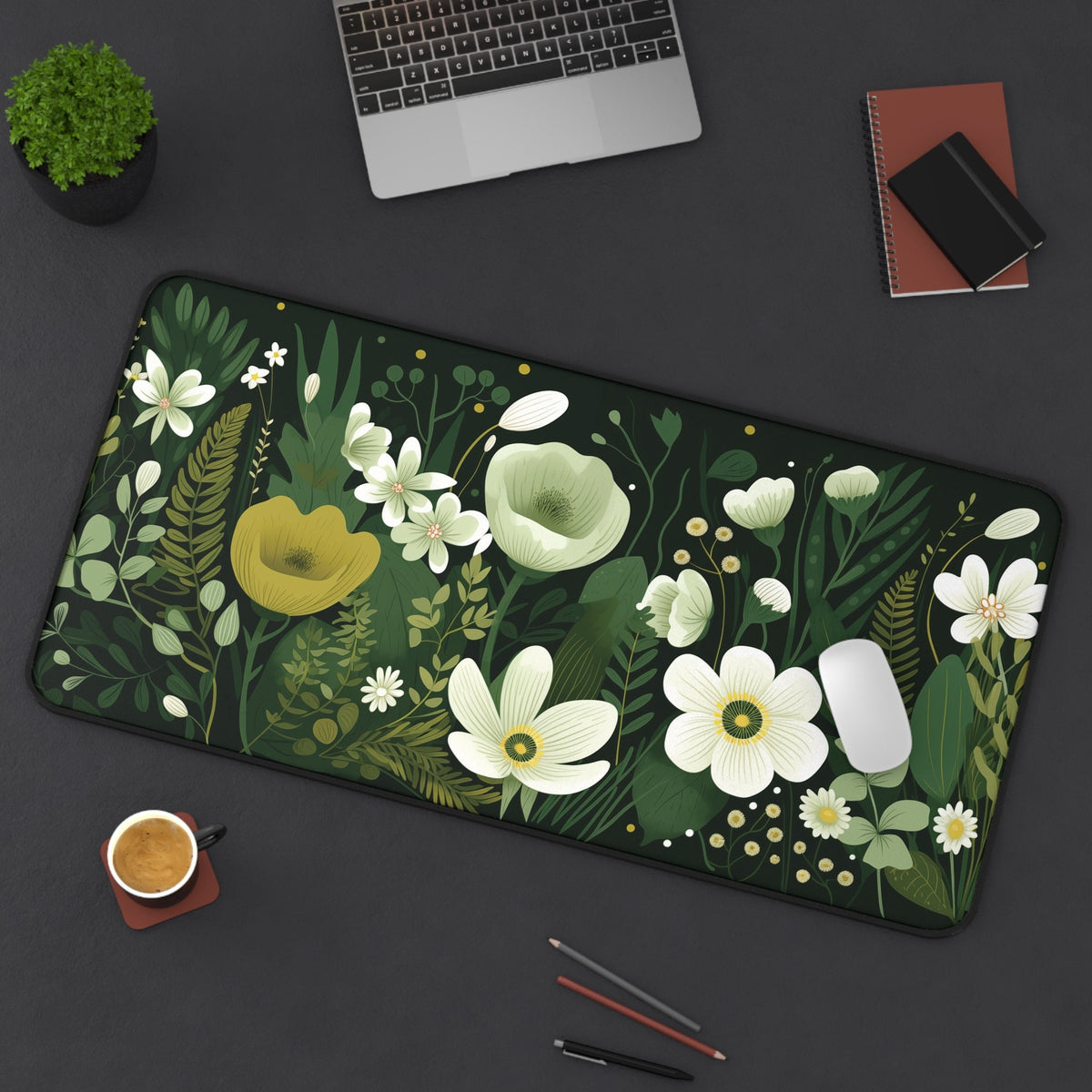 Dark Floral Desk Mat 16 × 32 inches top-down on a desk with laptop, plant, coffee, notebooks, mouse and pencils.