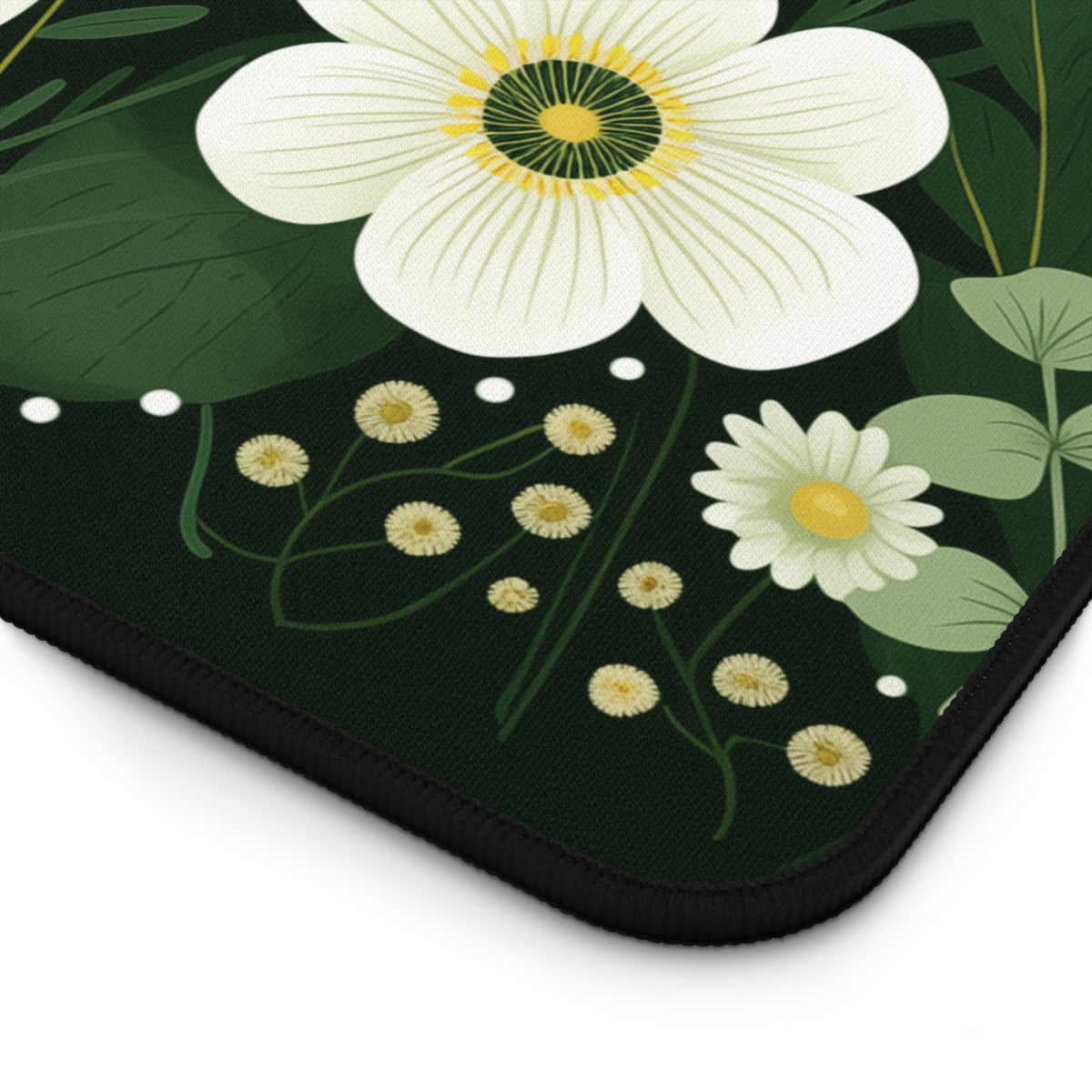 Dark Floral Desk Mat detail close-up of rounded corner with black stitched edge on plain white.