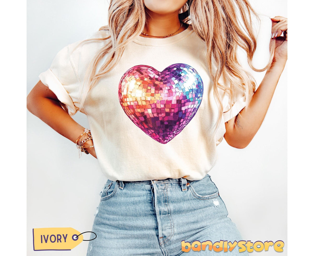 Disco Ball Heart T-Shirt in ivory on a front-facing model with blonde hair and blue jeans against a plain wall.