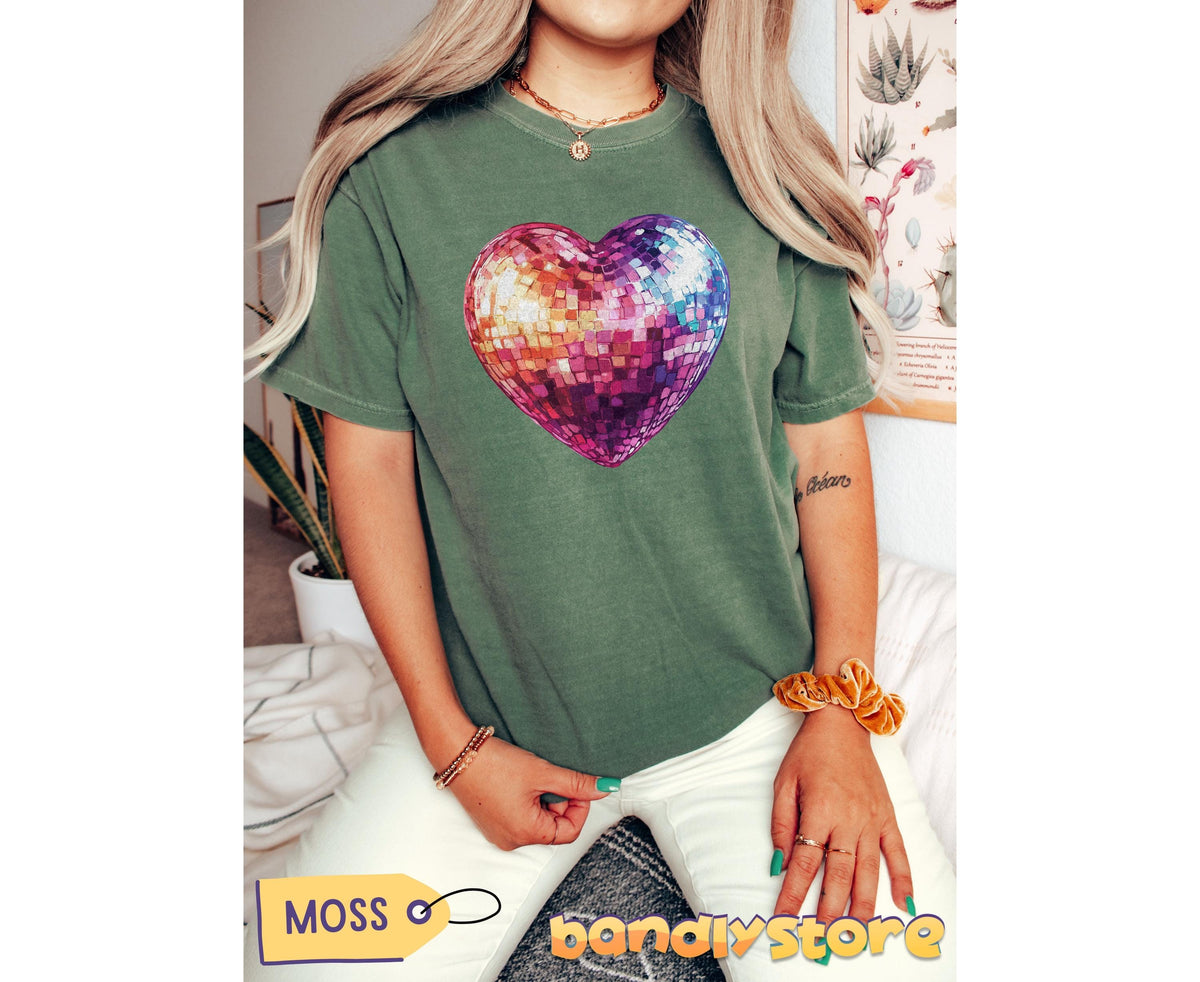 Disco Ball Heart T-Shirt in moss on a seated person facing forward with plants and botanical poster behind.