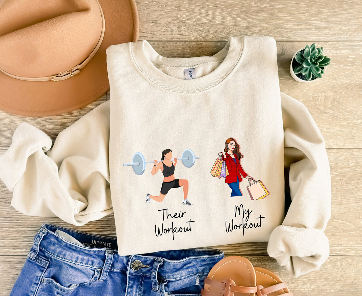 Funny Fitness Sweatshirt in sand, flat lay on wood with hat, jeans, sandals and plant beside gym vs shopping design.