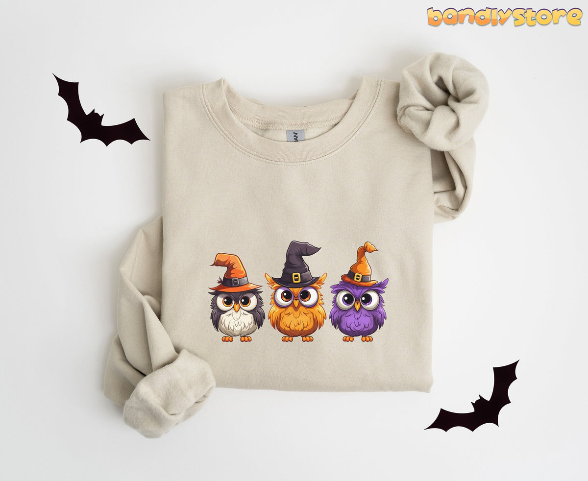 Halloween Owl Sweatshirt in sand folded flat on white background surrounded by black bat silhouettes.