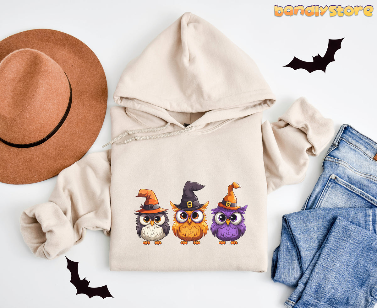 Halloween Owl Hoodie in sand flat-laid on white beside a brown hat, blue jeans and bat shapes.