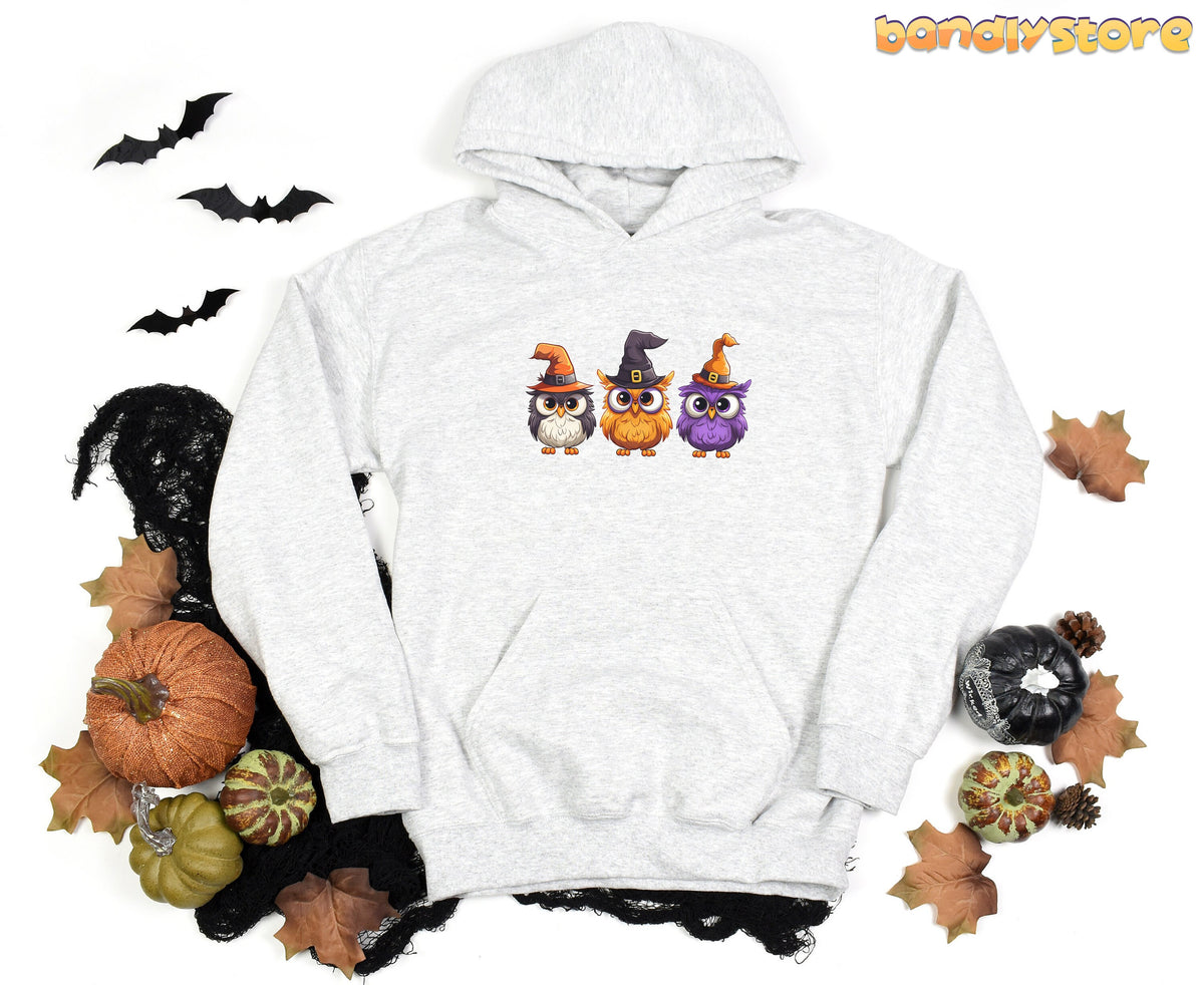 Halloween Owl Hoodie Sport Grey laid flat overhead amid bats, pumpkins, leaves and black netting.