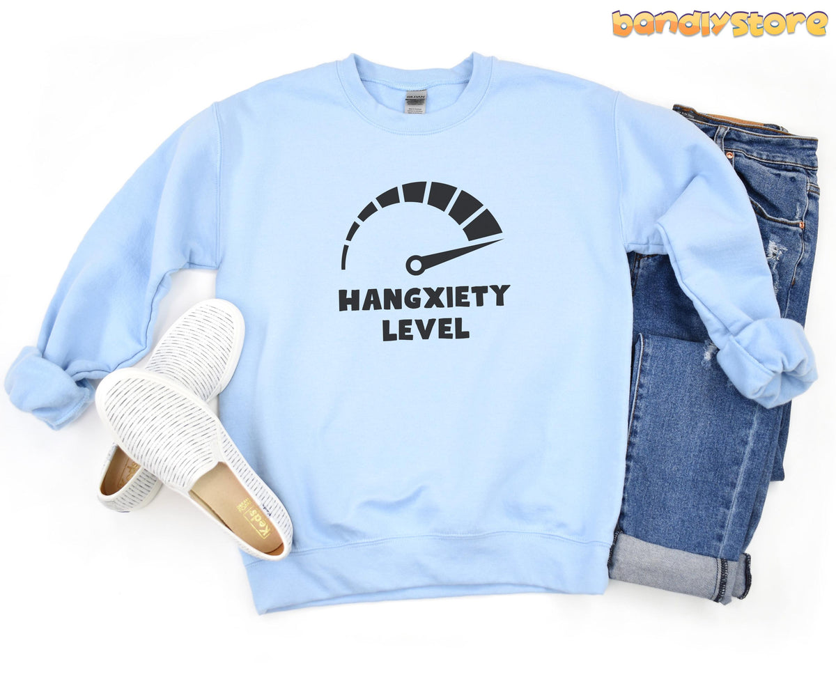 Hangxiety Hangover Sweatshirt in light blue laid flat on white beside white sneakers and blue jeans.