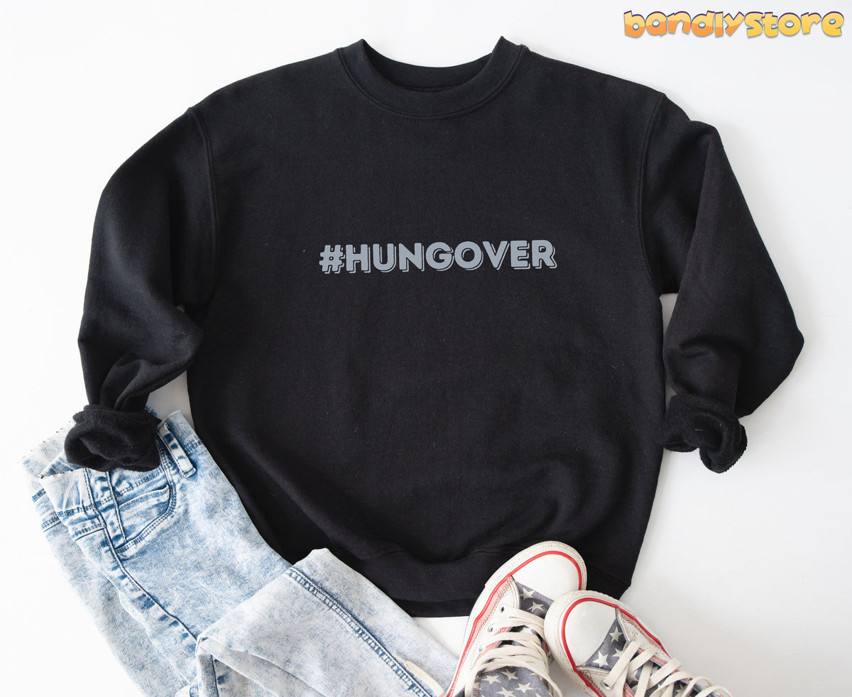 Hashtag Hangover Sweatshirt in black laid flat on white beside jeans and star sneakers.