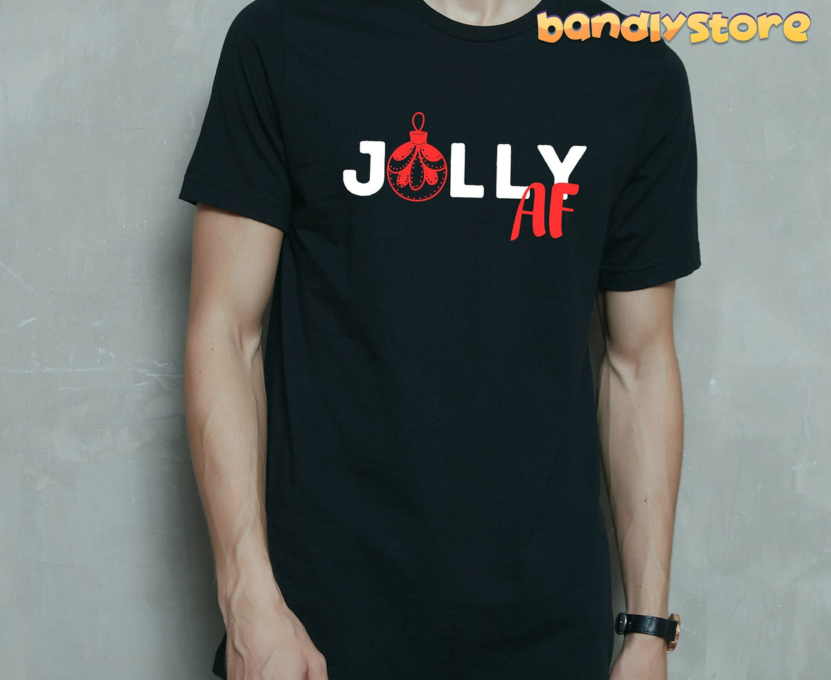 Jolly AF T-Shirt in black on a person facing forward against a plain gray wall.