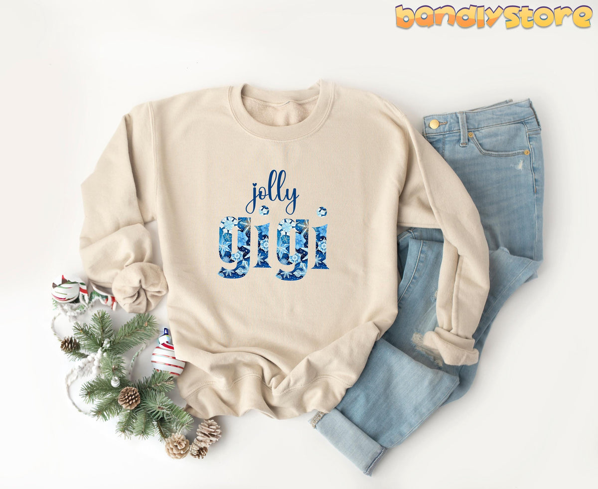 Jolly Gigi Sweatshirt in sand flat-laid from above beside jeans, pine greenery, ornaments and pinecones.