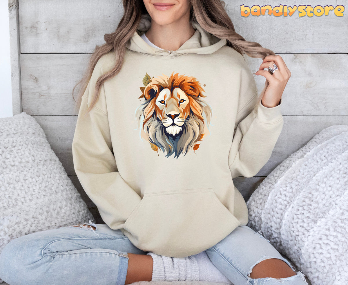 Majestic Lion Hoodie in sand on a person seated against a wood wall with white pillows.