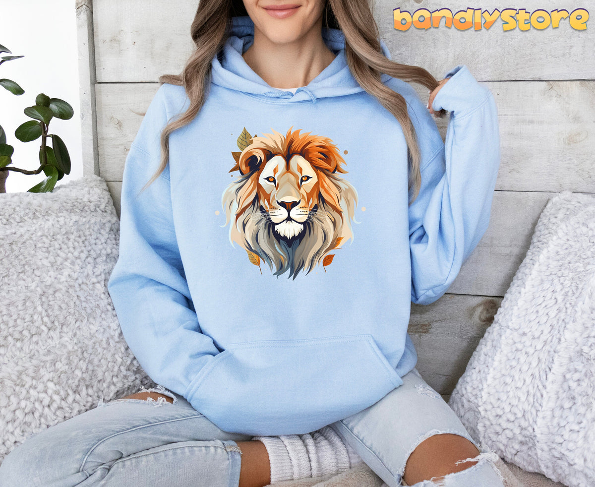Majestic Lion Hoodie in light blue on seated person, front view amid pillows and plant by wooden wall.