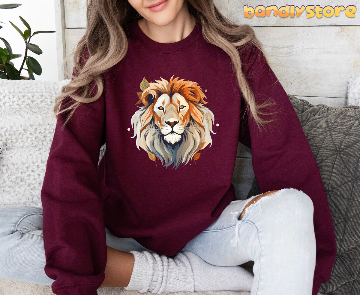 Majestic Lion Sweatshirt in maroon on a seated person amid couch pillows and a plant.