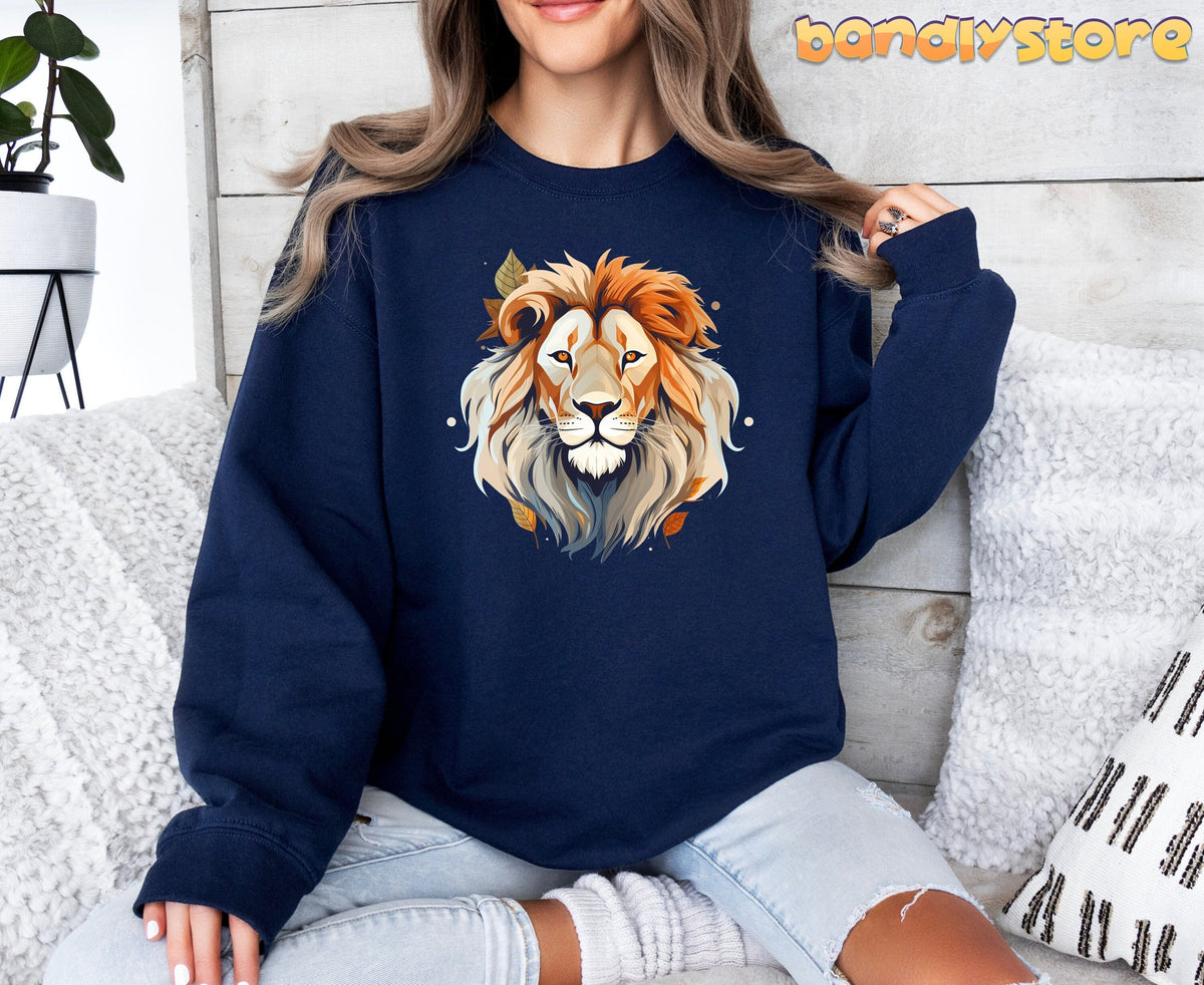 Majestic Lion Sweatshirt in navy on a seated model among white pillows and a plant by a wood wall.