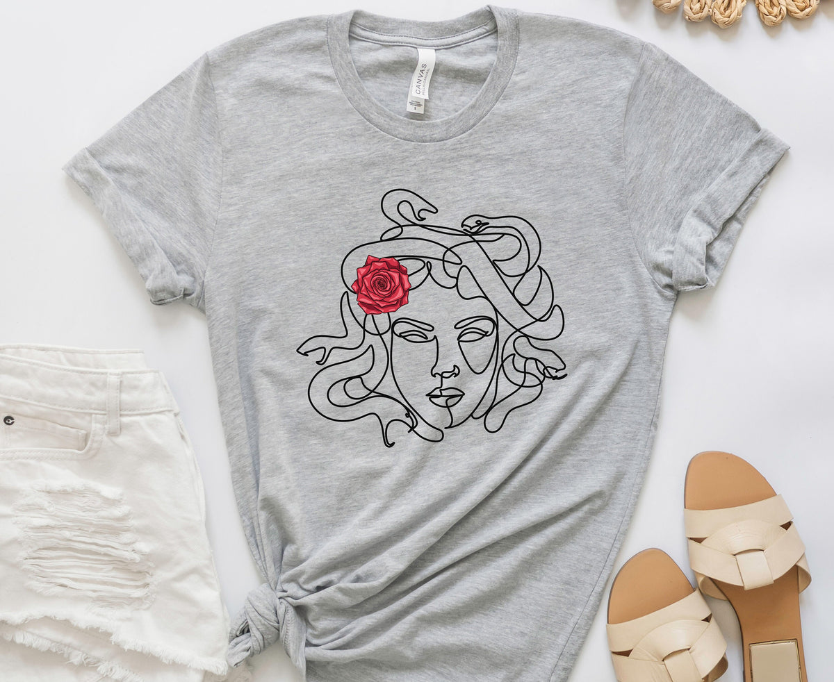 Medusa Head T-Shirt in Athletic Heather flat-laid top-down beside white jeans and beige sandals.