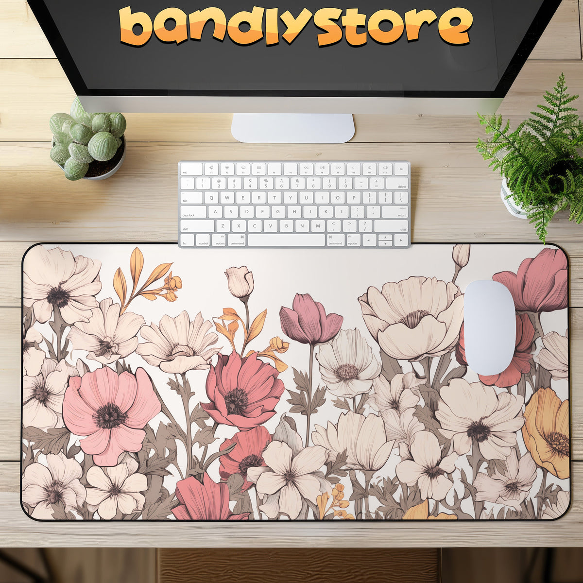 Pastel Floral Desk Mat on a light wood desk under a monitor, with keyboard, mouse and potted plants.