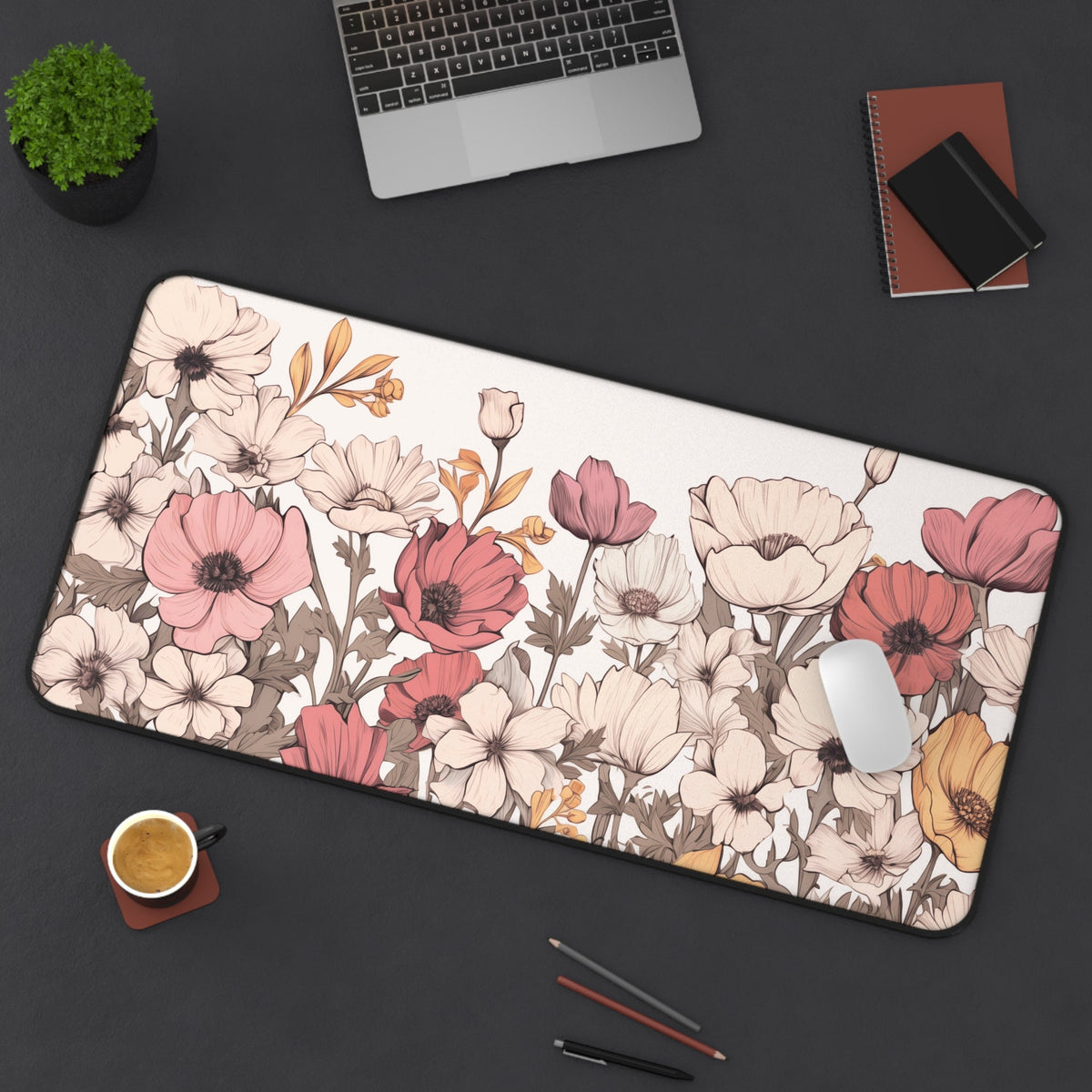 Pastel Floral Desk Mat in top-down view on a desk with laptop, plant, notebooks, coffee, mouse and pencils, 16 × 32 inches.