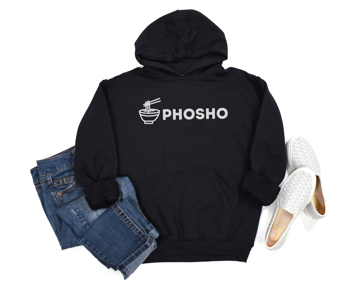 Pho Sho Hoodie in black laid flat from above beside folded blue jeans and white slip-on shoes.