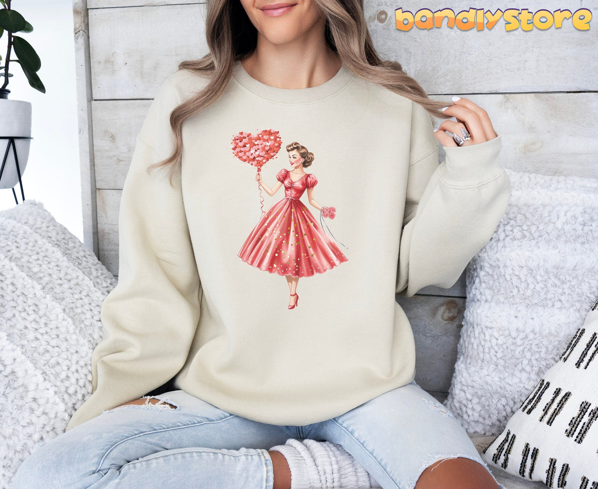Cute Valentine Girl Sweatshirt in sand on seated model against wood wall with pillows.