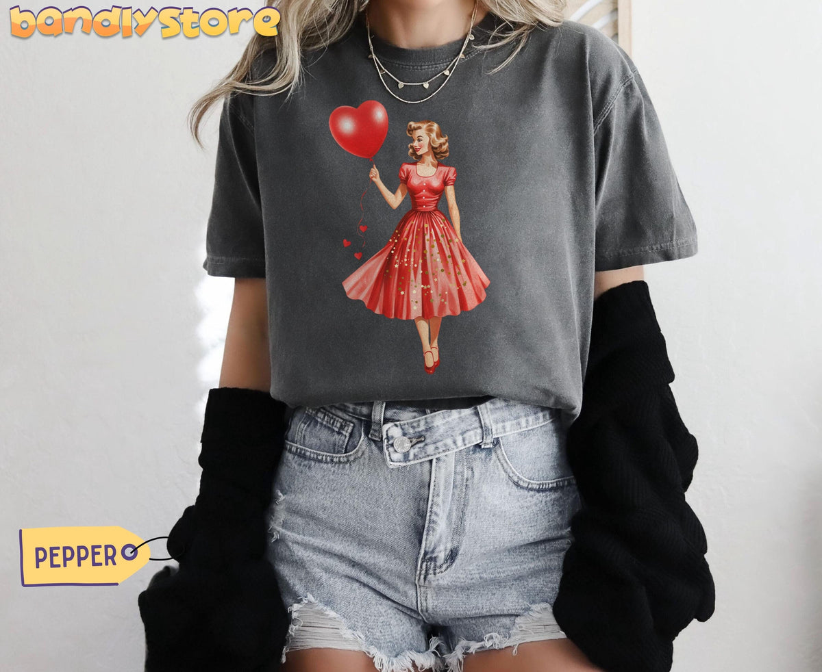 Vintage Valentines Day T-Shirt in Pepper, front view on a model with a retro woman holding a heart balloon graphic.