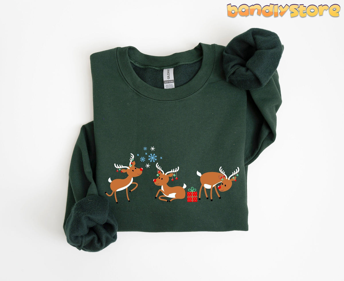 Rudolph The Red Nosed Reindeer Sweatshirt folded flat on white, forest green with three reindeer and snowflakes.