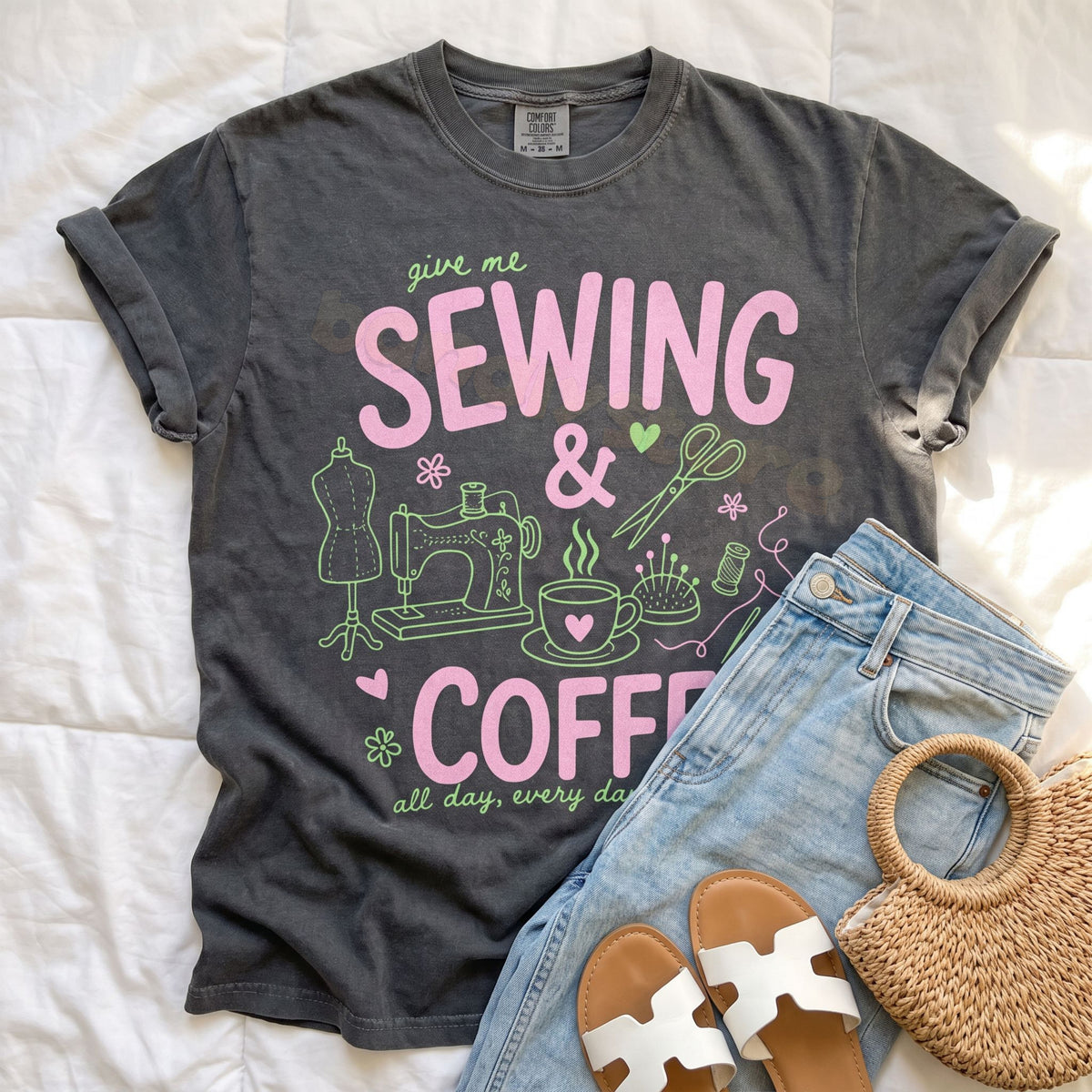 Sewing And Coffee T-Shirt in pepper laid flat on white bedding next to jeans, sandals and a woven bag.