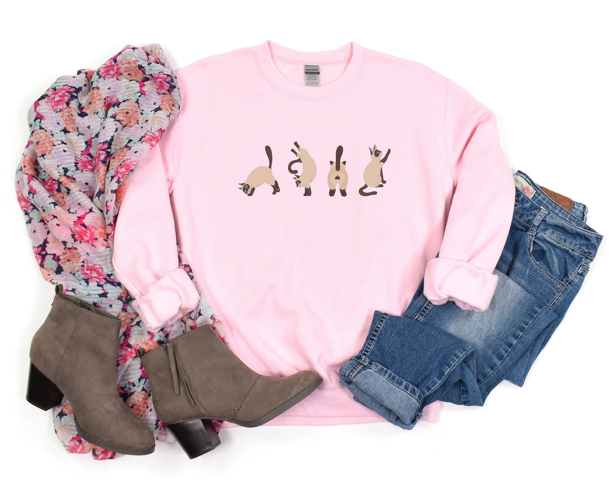 Siamese Cat Butts Sweatshirt in light pink flat-laid with floral scarf, gray boots, and blue jeans.