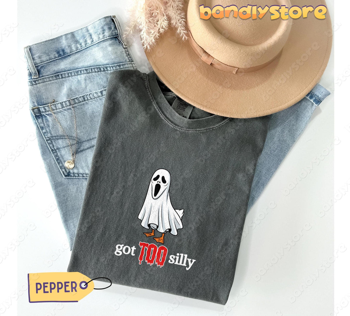 Silly Goose T-Shirt in Pepper laid flat beside light-wash jeans, a beige hat, pampas grass and a necklace.