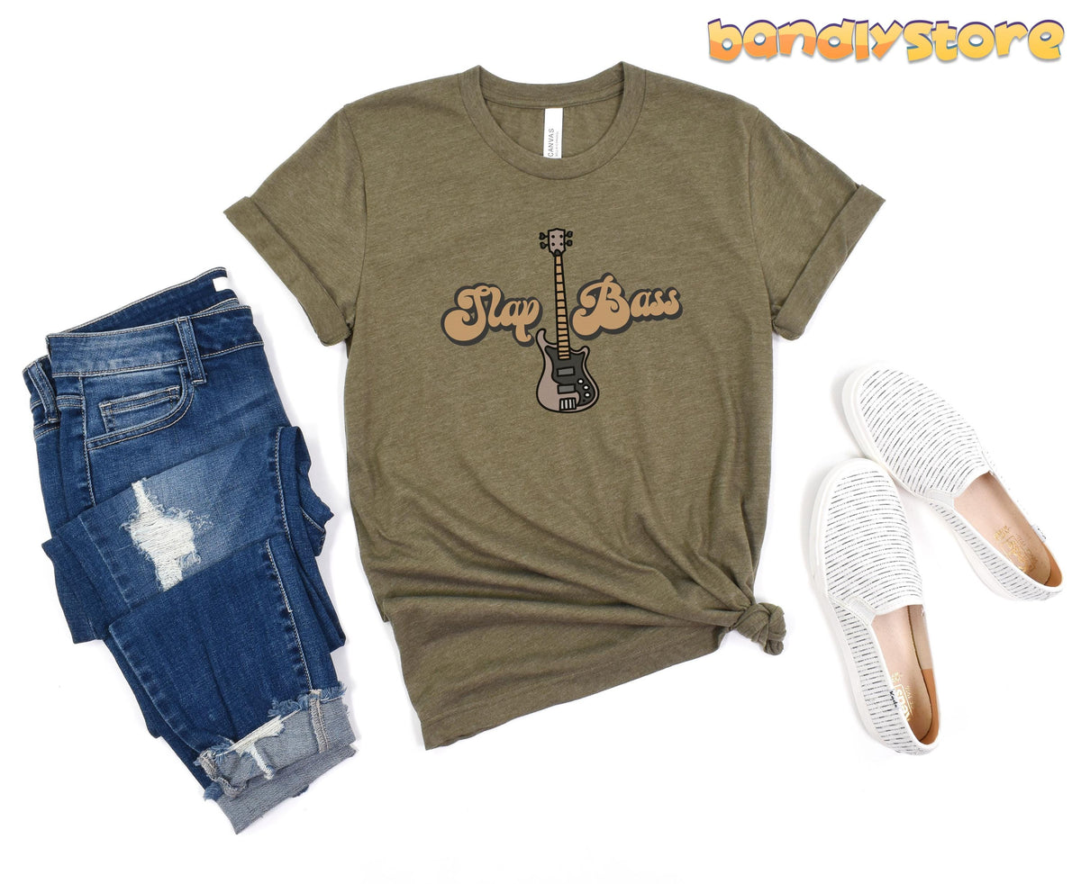 Slap Bass T-Shirt in Heather Olive laid flat next to ripped jeans and white slip-on shoes.