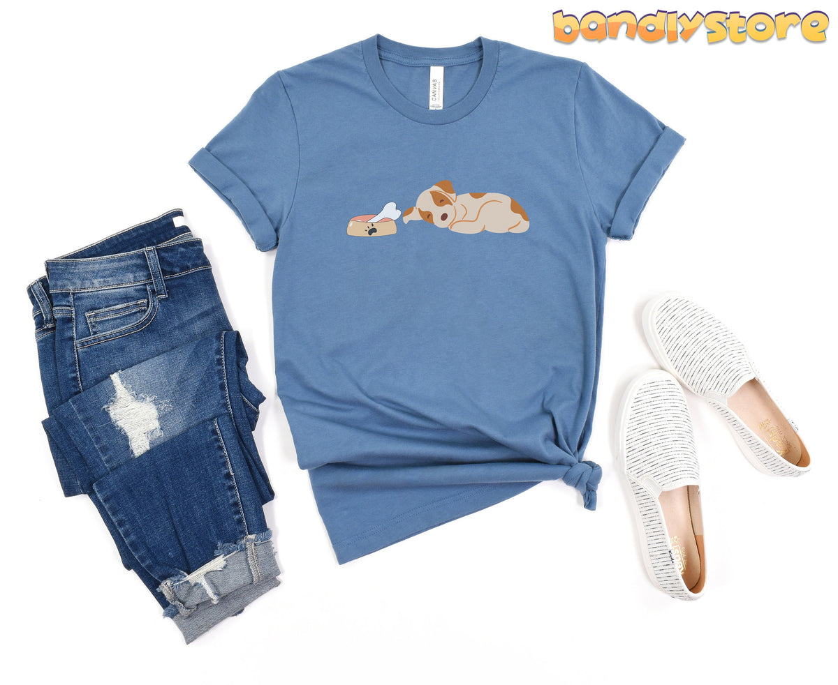 Sleeping Dog T-Shirt in steel blue laid flat beside ripped jeans and white slip-on shoes.