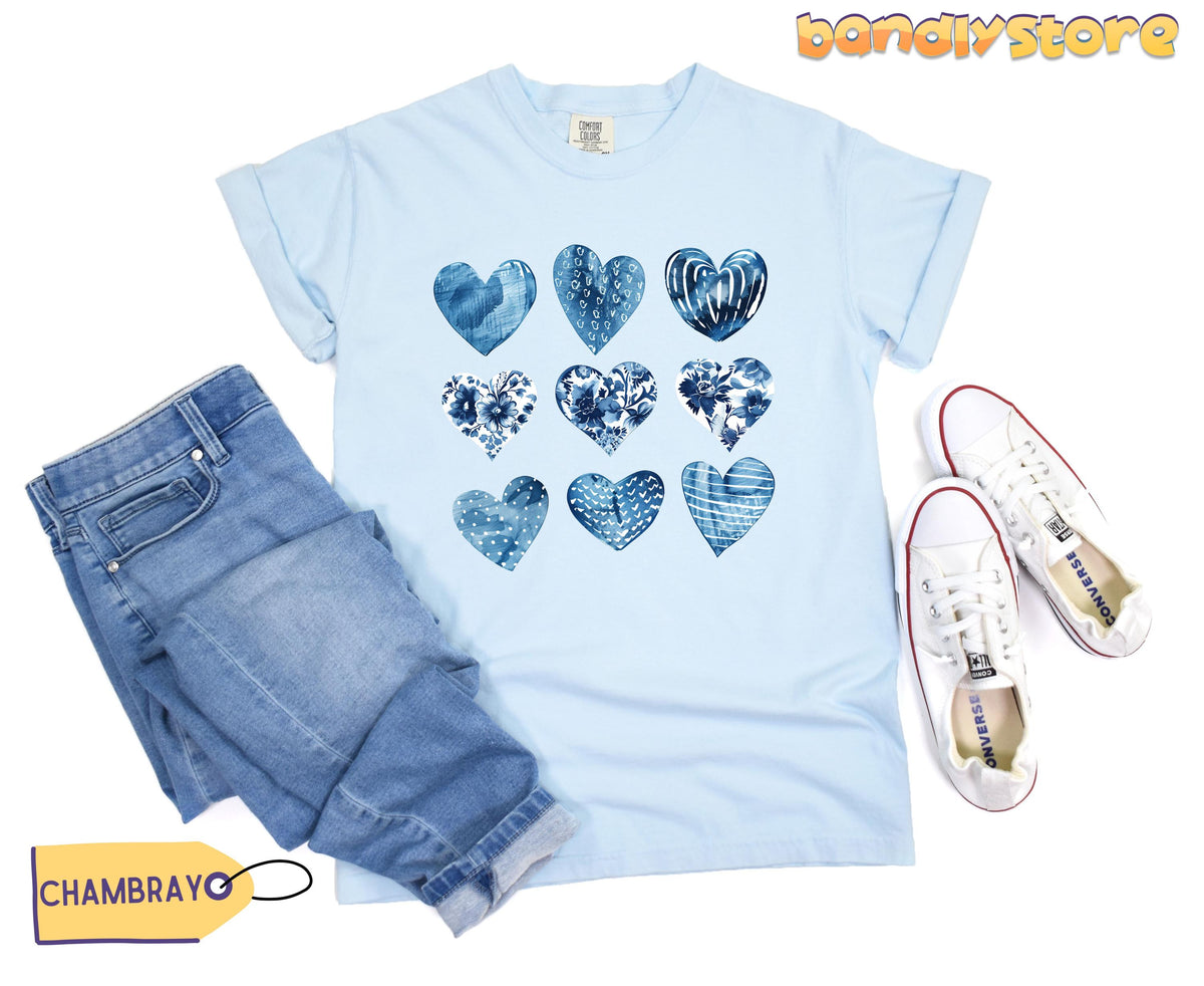 Toile De Jouy Hearts T-Shirt in Chambray, flat-laid with folded jeans left and white sneakers right.