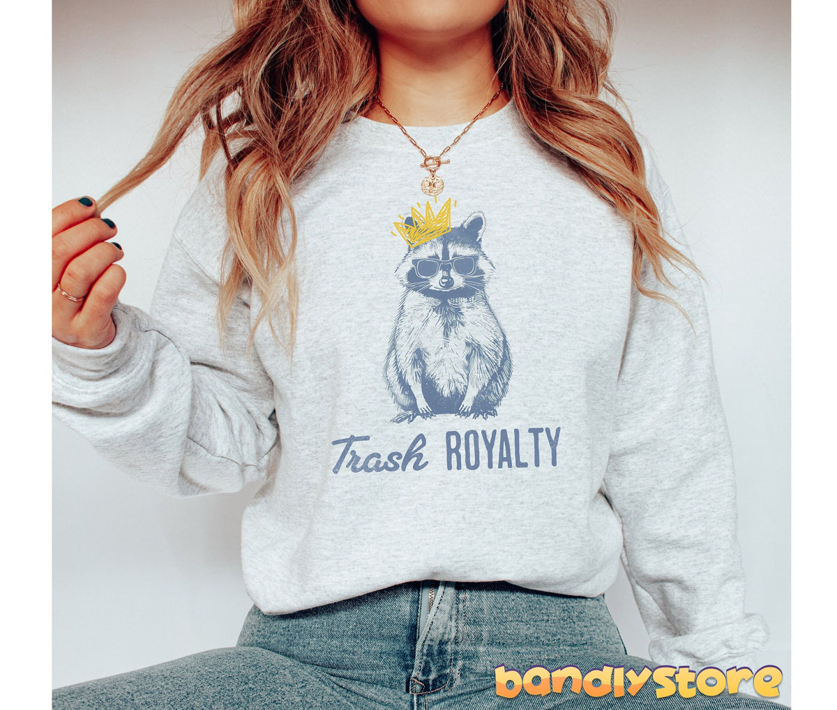 Trash Royalty Raccoon Sweatshirt in ash on a model with long hair and necklace, front view against plain white background.