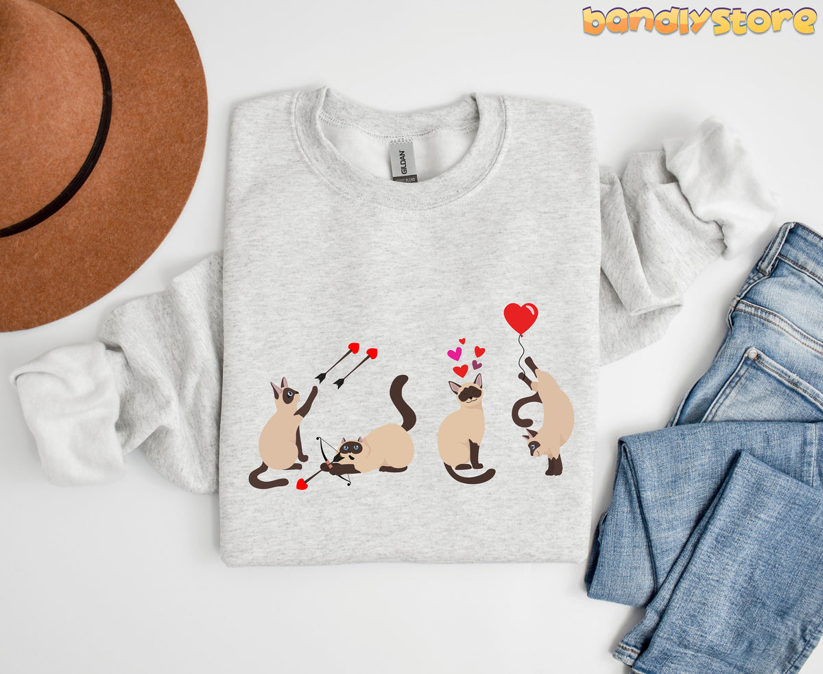 Siamese Cat Valentine Sweatshirt in ash, top-down flat lay beside brown hat and blue jeans.