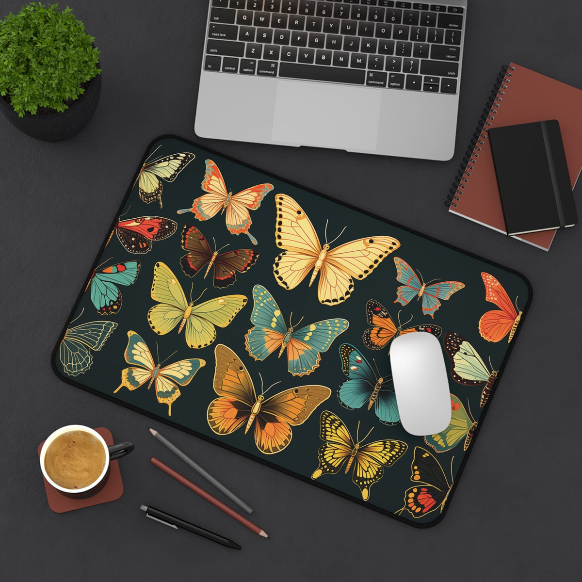 Vintage Butterflies Desk Mat in overhead view on desk with laptop, plant, notebooks, mug, pens, mouse, 12 × 18 inches.
