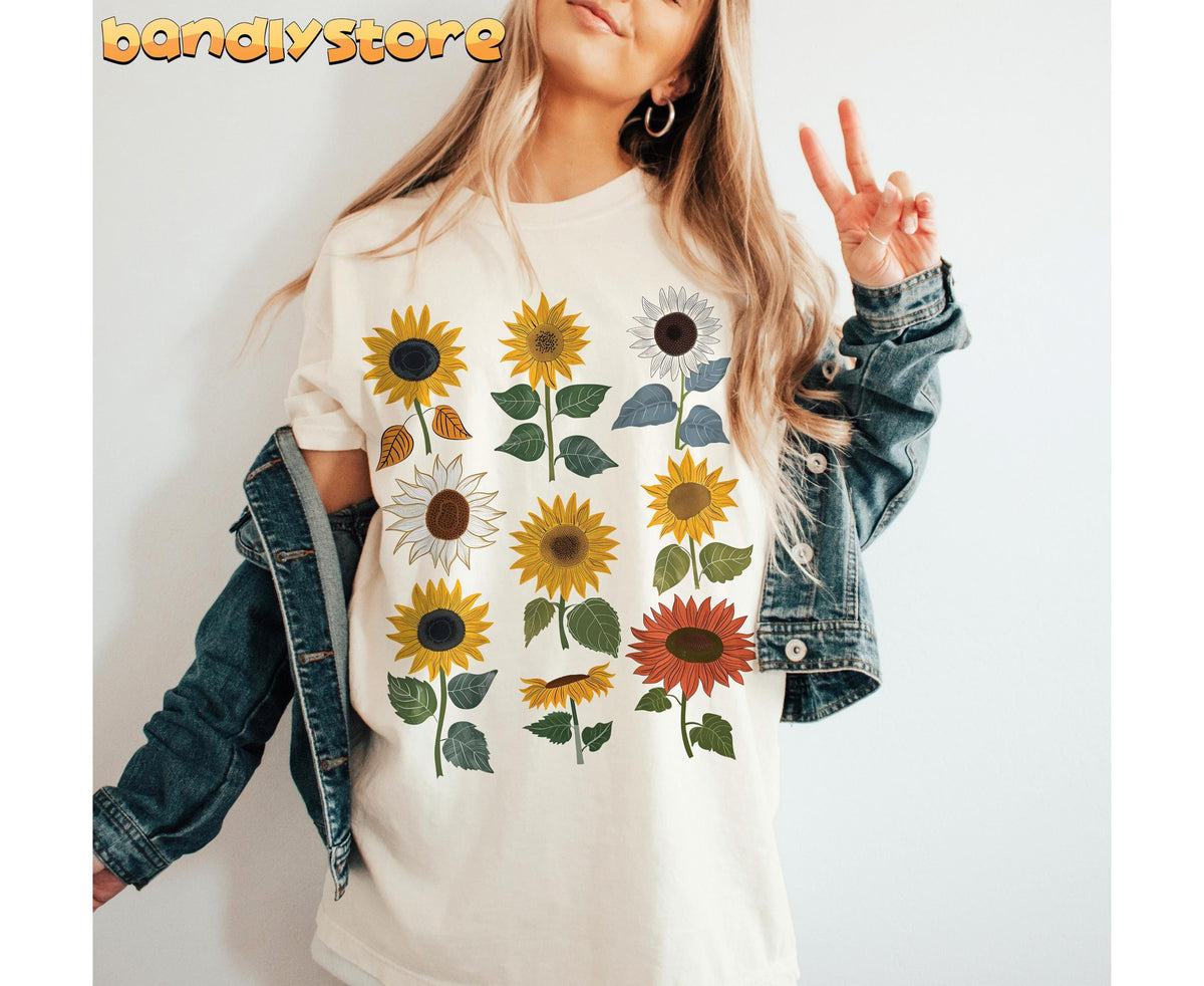 Vintage Sunflower T-Shirt in ivory on woman making peace sign with denim jacket draped, plain wall behind.