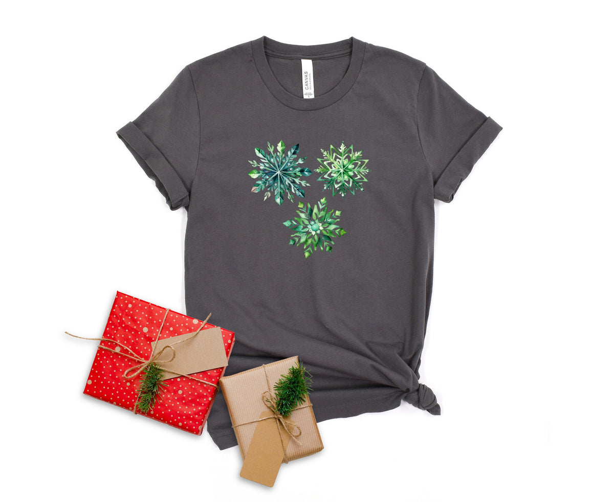 Watercolor Snowflakes T-Shirt in asphalt laid flat from above beside two wrapped gift boxes.