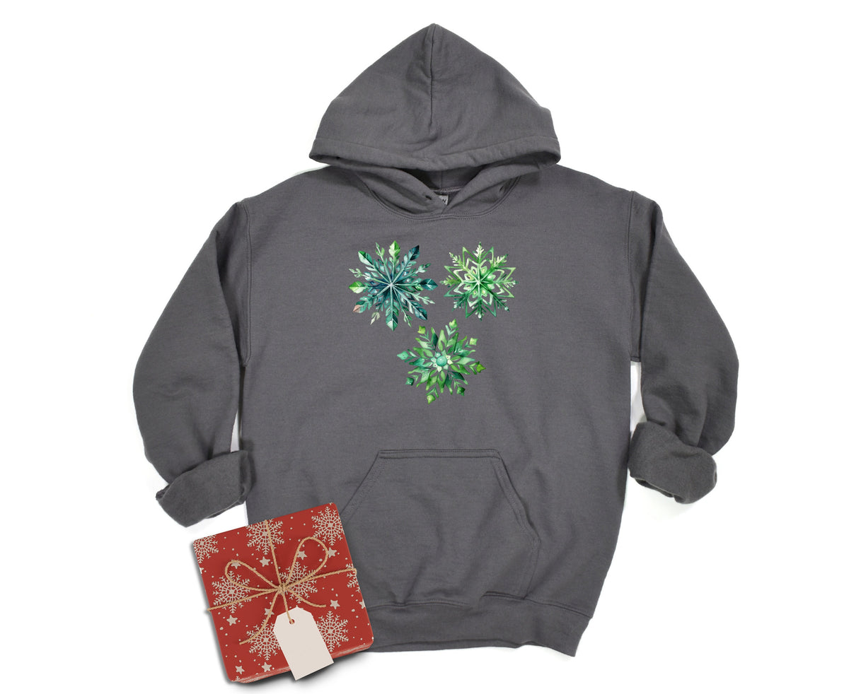 Watercolor Snowflakes Hoodie in charcoal laid flat on white beside a red gift box.