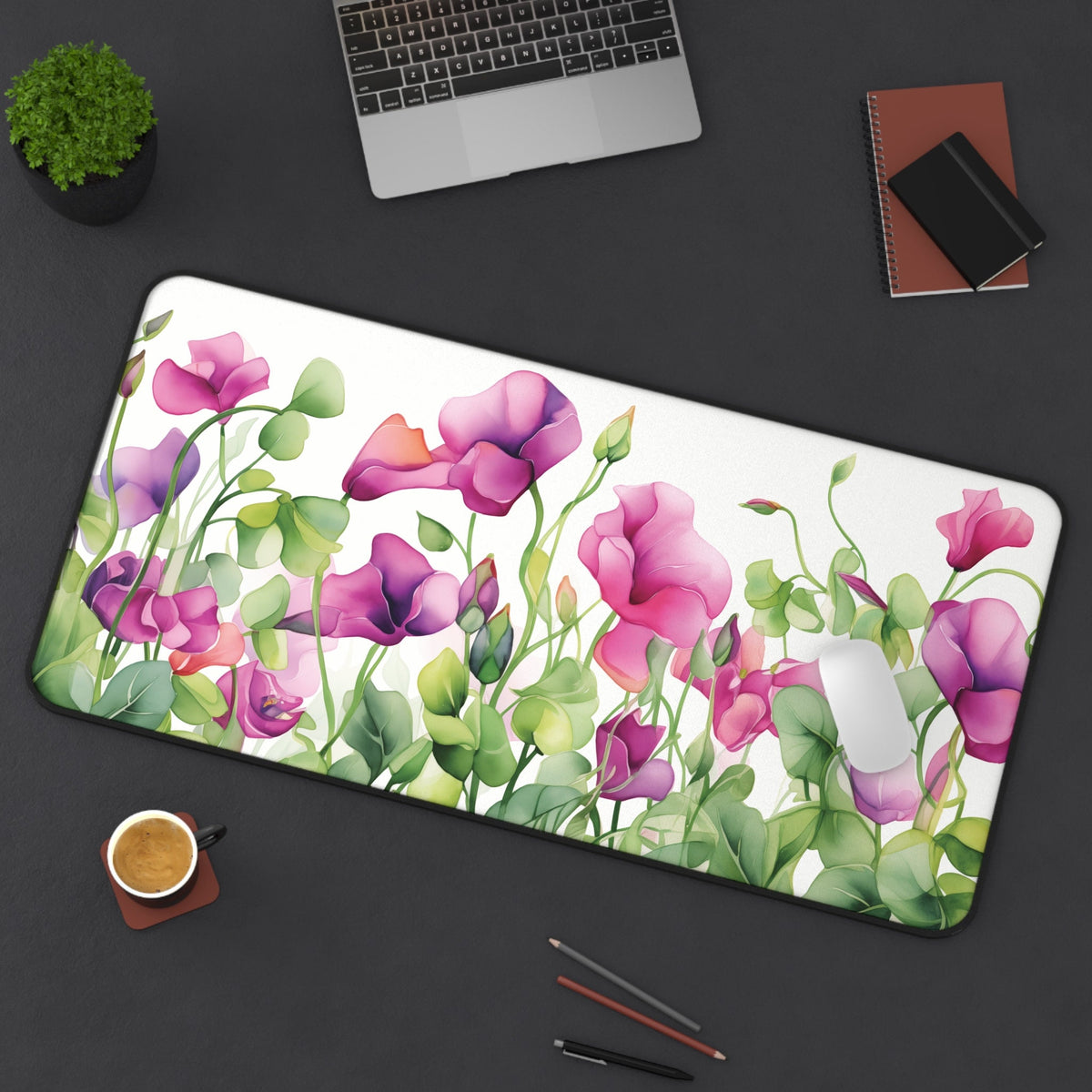 Watercolor Sweet Pea Flowers Desk Mat on a dark desk with laptop, plant, notebooks, coffee, pencils, and mouse; 16 × 32 inches.